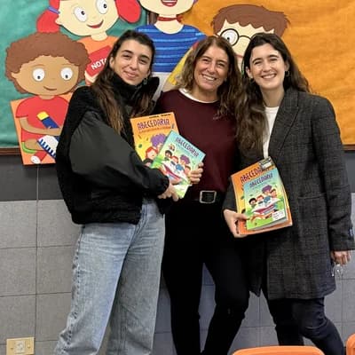 Tres integrantes del equipo con los libros de Abecedaria en un aula